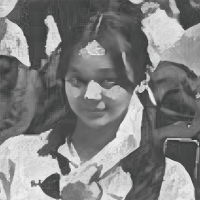 A grayscale portrait of a young person with long dark hair, wearing a collared shirt, and looking directly at the camera. The background features indistinct shapes and figures.