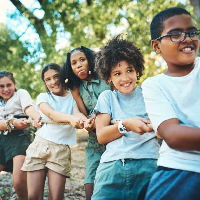 the winning team works as one a group of teenagers playing a game of-tug-of-war-